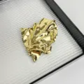 Detailaufnahme einer großen goldenen metallischen zerknitterten Brosche für stilvolle Anzüge. - Unregelmäßiger Faltenstil (Z-2163) / Gold
