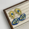 Boucles d'oreilles asymétriques vintage œil bleu strass avec pendentif doré élégant. - Boucles d'oreilles Œil maléfique bleues Z-1677 (tiges en argent S925)