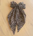 Eleganter Haarclip mit Leopardenmuster, glitzernden Strasssteinen und langen Luftschlangen. - Mit Strass / Helles Leopardenmuster