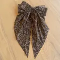 Nahaufnahme einer Vintage-Haarklammer mit Leopardenmuster-Schleife und langen Bändern. - Mit Strass / Dunkles Leopardenmuster