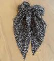 Nahaufnahme einer Vintage-Haarspange mit schwarz-weißer Leoparden-Schleife und Bändern - Klassisch / Schwarz Leopard