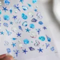 Nagelsticker-Bogen mit Meeresmotiven wie blauen und lila Muscheln und Seesternen - TS-752 Cool Shell-Geprägt