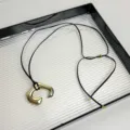 Close up view of stylish gold pendant black leather cord necklace, exquisite accessory detail. - Black Leather Cord (Z-2616) / Gold