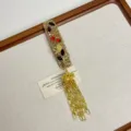 Nahaufnahme des eleganten Strass-Haarclips mit goldenen Quastenketten und Blumendekor. - Blatt-Stil (Z-3864)