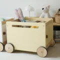 Chariot de rangement jouet en bois pour enfants avec roues en jaune pastel pour chambre. - Jaune