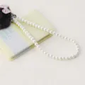 Elegante witte parelketting met schattige harige strikdecoratie voor tassen en knutselaccessoires. - Parelketing / Wit