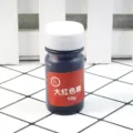 Detail shot of 10g red epoxy resin pigment dye bottle for crystal glue and resin crafts close up. - Bright Red