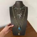Nahaufnahme der mehrlagigen Halskette mit blauer Emailleschleife und Erdbeeranhänger detail. - Blau Erdbeere Herz Kette (XL5015)