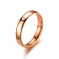 Gros plan d'une bague minimaliste en or rose avec une seule pierre et un anneau poli. - Taille 7 / Or rose