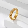 Gros plan detaille d'un bague anti-stress en acier dore avec texture mat et decoupes etoile lune. - Taille 5 / Or Rotatif