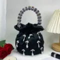 Sac à main seau en satin noir avec poignée en perles de cristal et pendentifs élégants. - Noir