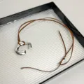 Long brown leather cord necklace featuring a stylish silver metallic C-shaped pendant for women. - Brown Leather Cord (Z-2619) / Silver