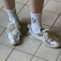 Silver metallic sneakers with pearl bow accessories and white socks, fashionable footwear. - White