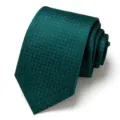 Dark green men's tie featuring a detailed jacquard pattern, shown neatly rolled for formal wear. - Dark Green