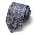 Close-up detail of a rolled men's floral jacquard necktie featuring blue and pink flowers. - Dark Blue