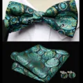 Close-up detail of men's black and teal jacquard bow tie, pocket square, and matching cufflinks set. - JP185