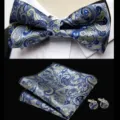 Closeup of blue and gold paisley bow tie, pocket square, and cufflinks detail for formal wear. - JP187