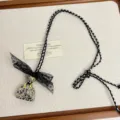 Chic black lace bow dalmatian jasper handbag pendant necklace, elegant niche design detail. - Polka Dot Stone Bags Z-4434 / Spotted Stone
