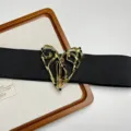 Close-up detail of women's black elastic waist belt with ornate gold-tone abstract heart metal buckle. - Abstract Heart Buckle Style (H-41) / Gold