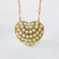 Closeup detail of the glamorous heart-shaped pearl rhinestone evening bag with gold chain strap. - Arc Shape Style / Gold