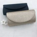 Glitzernde Abendtasche Detailansicht, schimmernde Stofftextur und eleganter Klappverschluss. - Champagner