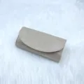 Detailaufnahme einer goldenen Glitzer Abendtasche mit funkelndem Stoff und elegantem Klappendesign. - Champagner