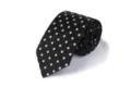 Nahaufnahme einer schwarz-weißen Krawatte mit Polka-Dots, die die feine Stofftextur zeigt. - L7020