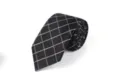 Detailed view of the elegant black rolled tie featuring sharp white and purple grid patterns. - L7009 (Black Plaid)