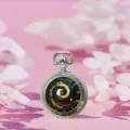 Vintage silver quartz pocket watch with galaxy spiral dial and elegant floral background. - Mystical Eye