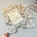 Detailed view of a elegant floral silk scarf, featuring delicate blue flower prints on a soft square fabric. - SJ187-JKF