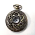 Orologio da tasca cavo in bronzo vintage con intricato design floreale e quadrante classico. - Bronzo Cavo