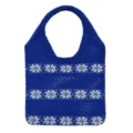 Nahaufnahme der blauen Strick-Tragetasche mit ausgearbeitetem weißen Schneeflocken-Muster. - Blau