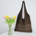 Nahaufnahme Detailansicht einer braunen gehäkelten Beuteltasche mit schönem Strickmuster. - Kaffeebraun