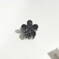 Primo piano dettagliato di un mini fermaglio per capelli a fiore in metallo con strass scuri. - Pieno Strass Canna di Fucile Fiore