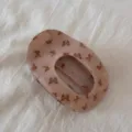 Close-up detail of the pink oval hair claw clip with delicate butterfly prints for women. - Small Butterfly
