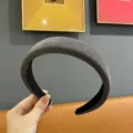 Vista detallada de diadema de terciopelo ancho, relleno grueso y textura suave para uso diario. - Gris