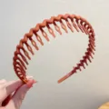 Gros plan détail du serre-tête ondulé terracotta mat avec dents pour un usage quotidien - Style Ondulé Couleur Unie / Orange
