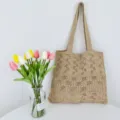Detailansicht der beigen Strick-Häkel-Tasche mit bunten Tulpen in Glasvase arrangiert. - Khaki