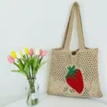 Nahaufnahme Detail der gestrickten hohlen Strand-Tote-Tasche mit rotem Erdbeer-Muster. - Khaki