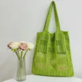 Detailaufnahme einer grünen Stricktasche, die feine Maschenmuster und die langen Henkel zeigt. - Obstgrün