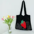 Schwarze gestrickte Häkel-Tote-Bag mit rotem Erdbeermuster für Strand und den Alltag. - Schwarz