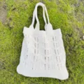 Vista dettagliata della borsa a tracolla traforata in maglia color crema con bella trama. - Beige