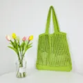 Grüne Häkelstrick Handtasche Detailansicht, offenes Netzdesign, lässige Umhängetasche. - Obstgrün