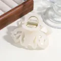 Detailed shot of a simple solid color hollow hair claw clip, elegant translucent design for thick hair. - Jelly White