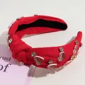 Detailed shot of a red knotted headband featuring sparkling rhinestones and cute heart charms. - Red Rhinestone Heart