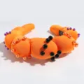 Detailed view of trendy orange padded cloud headband decorated with faux pearls for party. - Orange