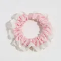 Detailed close-up of sweet pink satin hair scrunchie with elegant white lace trim design. - Pink