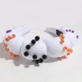 Close-up detail of white padded headband decorated with colorful faux pearls for parties. - White