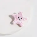 Gros plan d'une jolie pince à cheveux étoile de mer rose en acétate, accessoire doux. - Étoile de Mer Rose et Blanc
