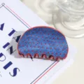 Primo piano dettagliato del fermaglio per capelli a pois blu e rossi, stile retrò. - semicircolare